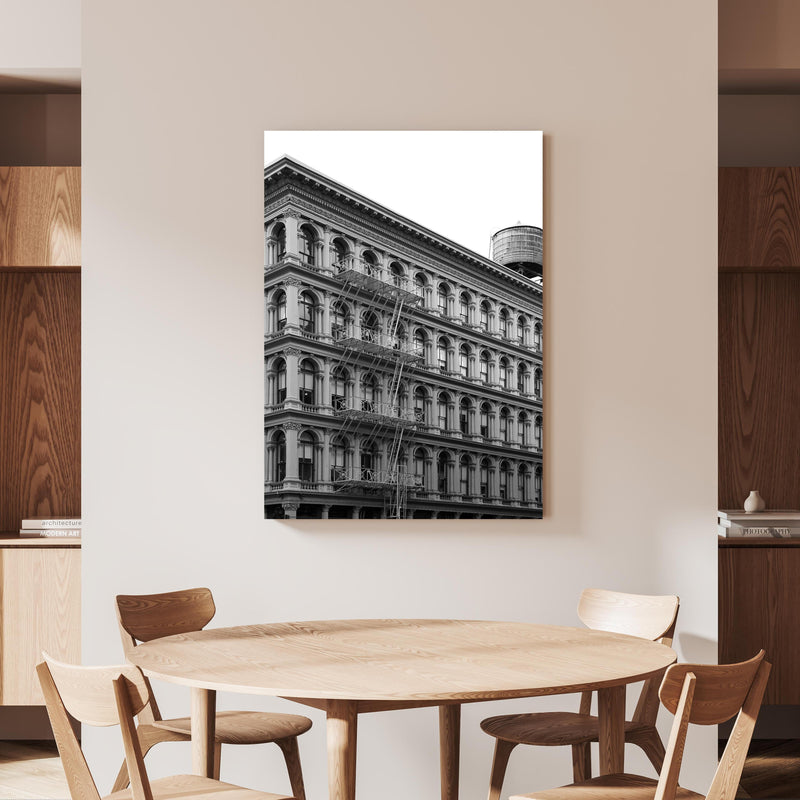 Wandbild - Gräuliches Foto - Architektur in NYC an beiger Wand hinter handgeschnitztem Holztisch 