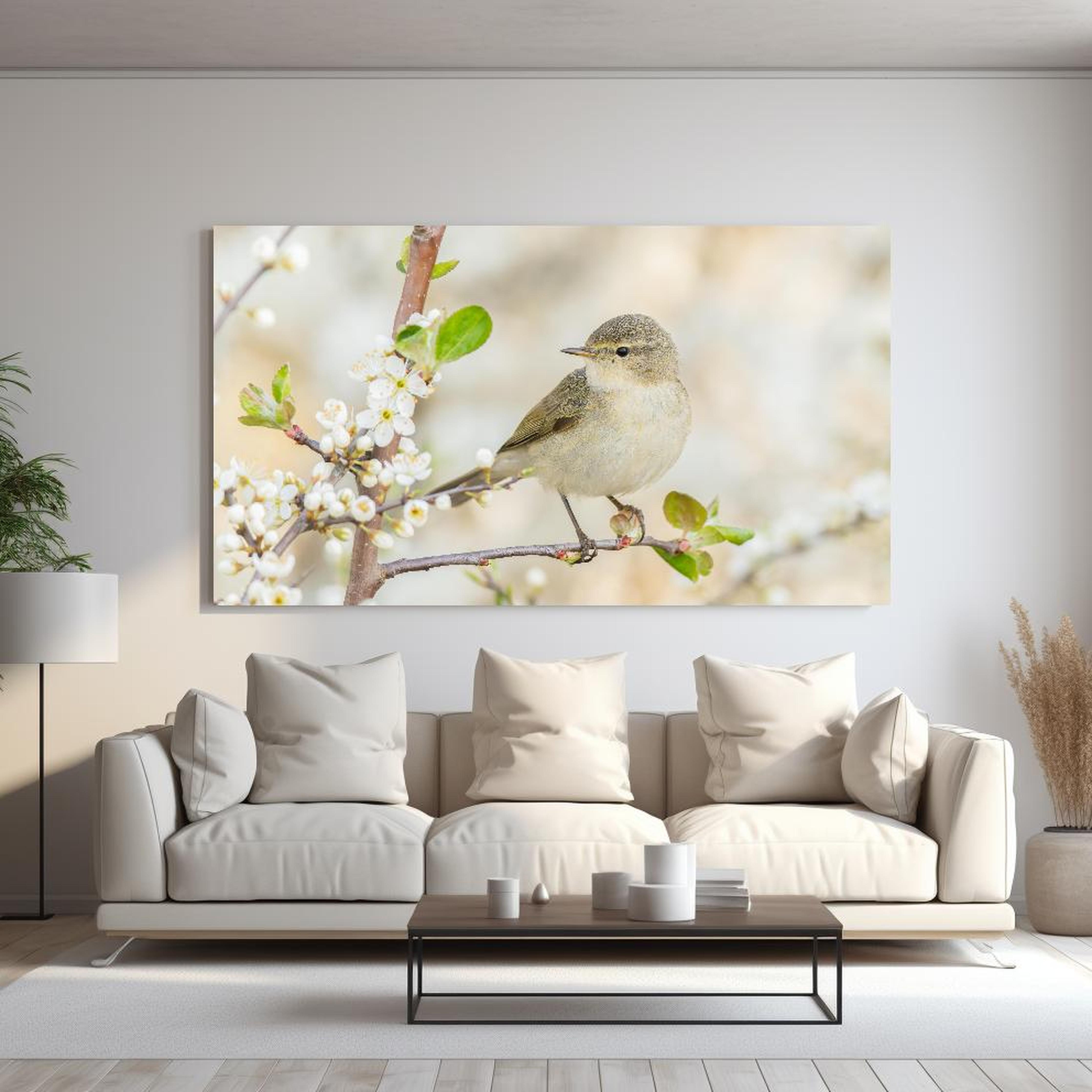 Wandbild - Kleiner Vogel am Baumzweig hinter sanfter Couch mit cremefarbenen großen Kissen