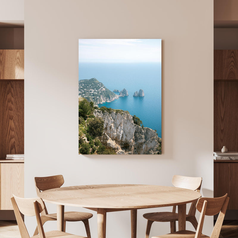 Wandbild - Küste von Capri, Italien an beiger Wand hinter handgeschnitztem Holztisch 