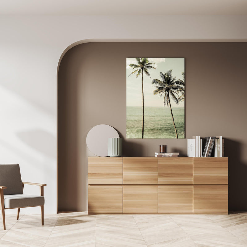 Wandbild - Meeresblick - Unter Palmen über doppelter Holzkommode mit Vase und Büchersammlung