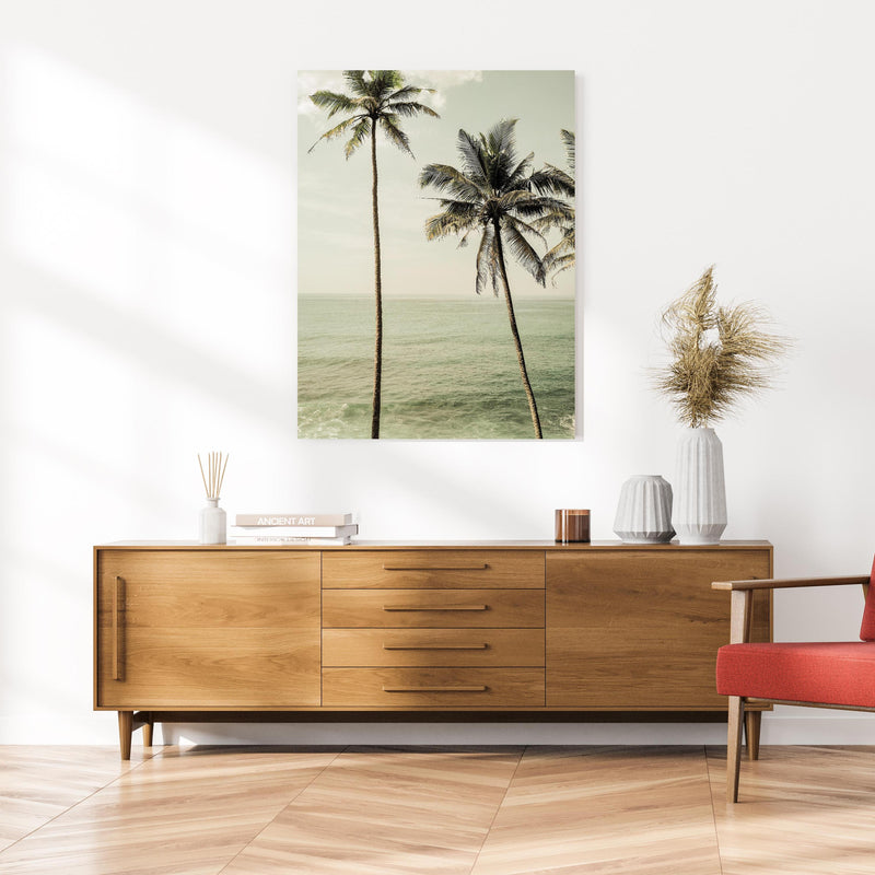 Wandbild - Meeresblick - Unter Palmen an cremefarbener Wand über klassischer Holzkommode