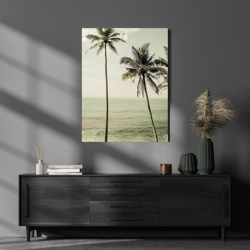 Wandbild - Meeresblick - Unter Palmen über luxuriöser Holzkommode und dunkelgrünen Vasen