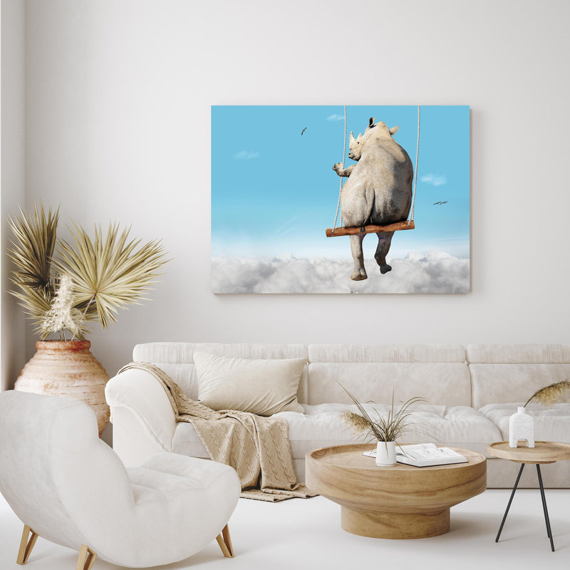 Wandbild - Nashorn schaukelt über den Wolken in exotisch eingerichtetem Wohnzimmer über gemütlicher Couch
