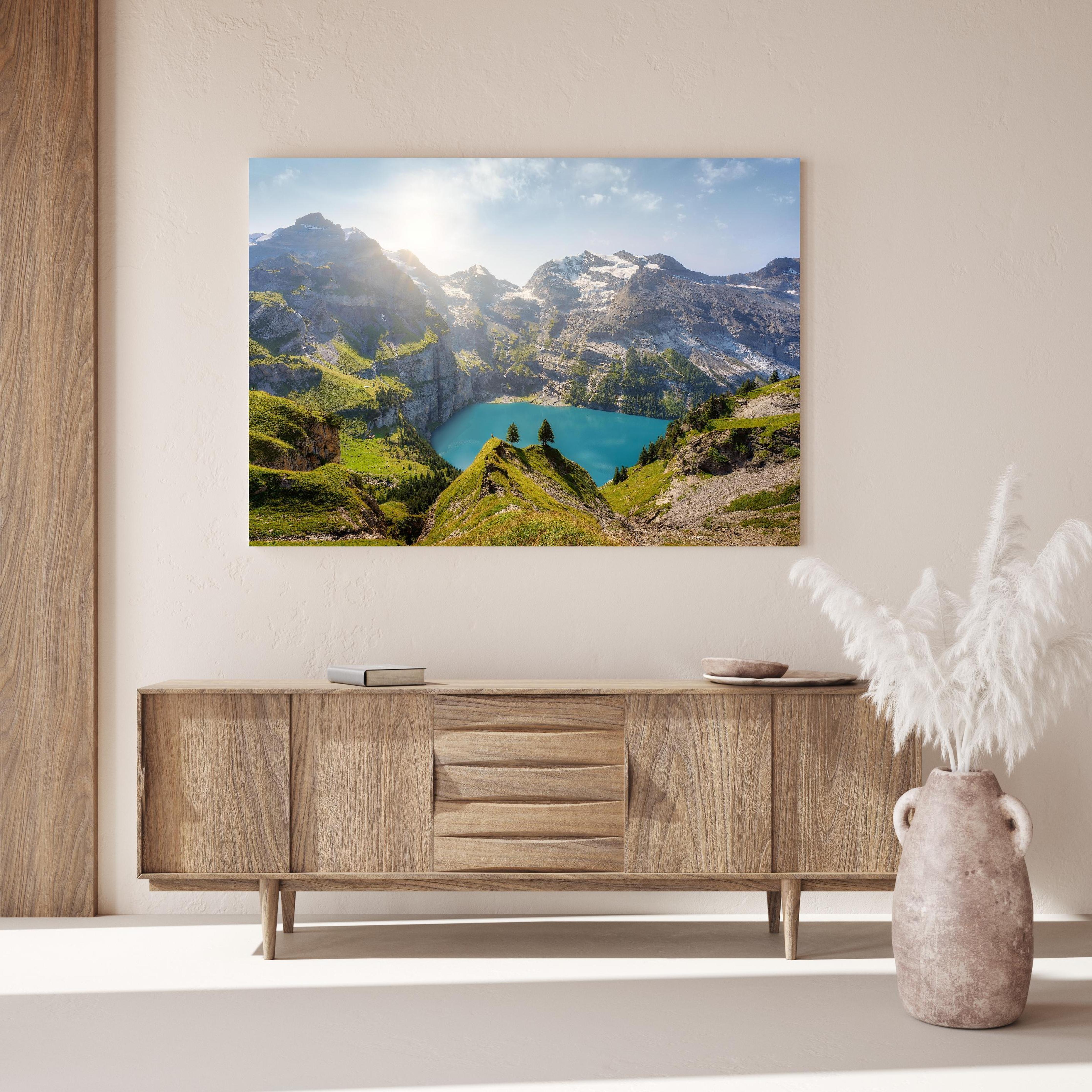 Wandbild - Oeschinensee in den Schweizer Alpen über Holzkommode hinter dekorativer Zimmerpflanze