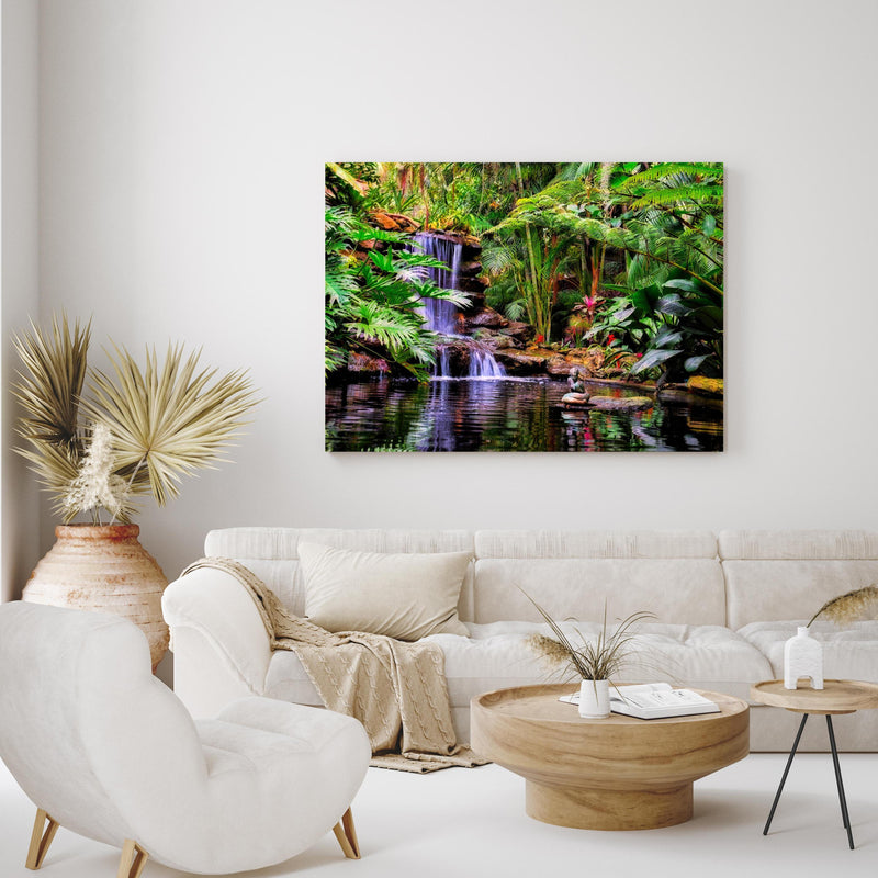 Wandbild - Tropischer Wasserfall in exotisch eingerichtetem Wohnzimmer über gemütlicher Couch