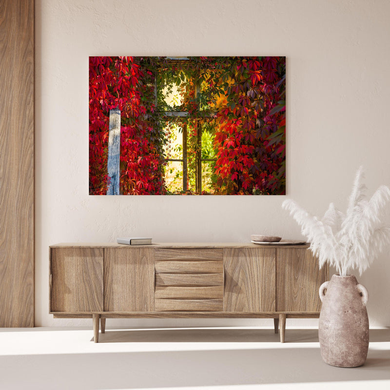 Wandbild - Verwachsenes Fenster mit roten Blättern über Holzkommode hinter dekorativer Zimmerpflanze