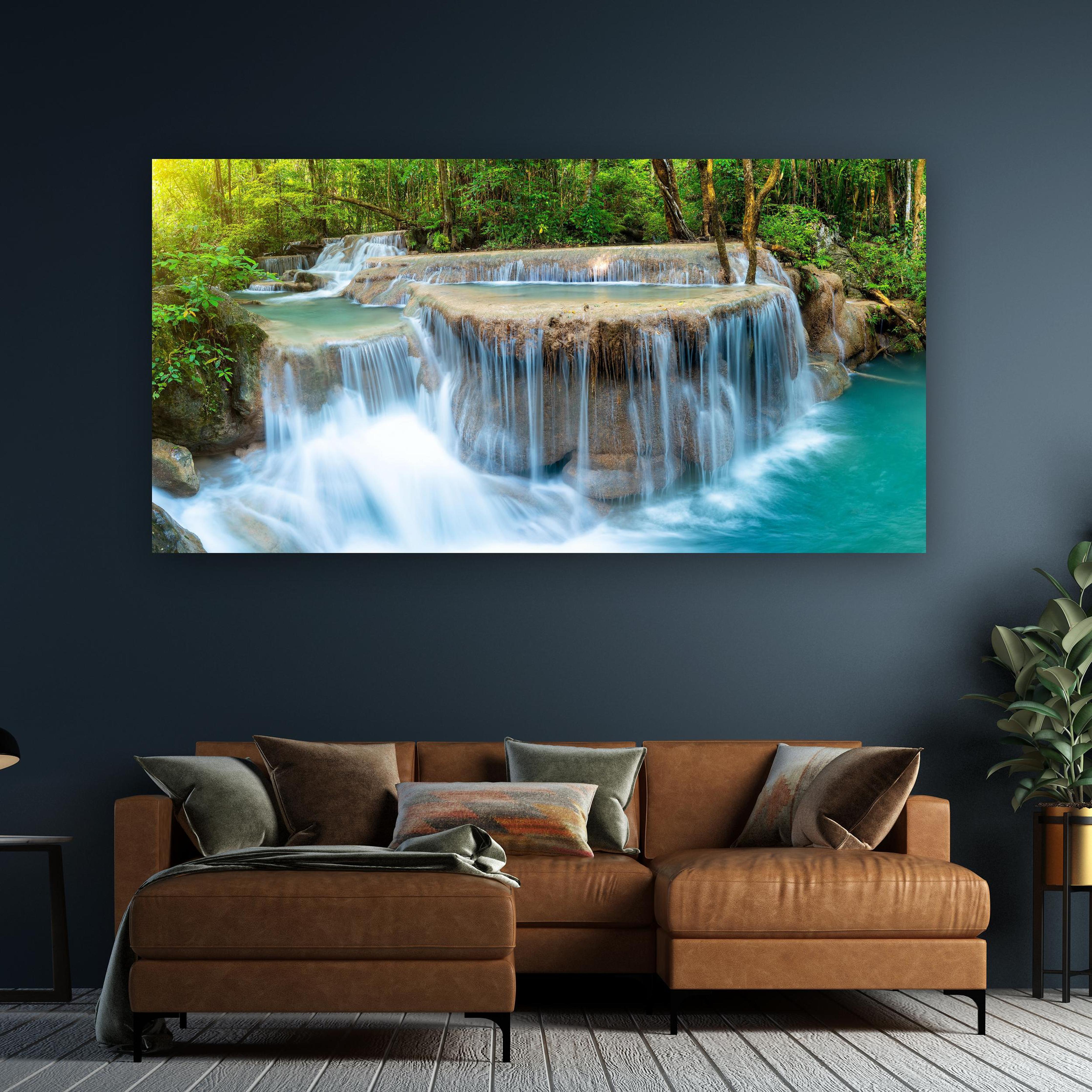 Wandbild - Wasserfall im Wald von Thailand an dunkelgrüner Wand über klassischem Sofa