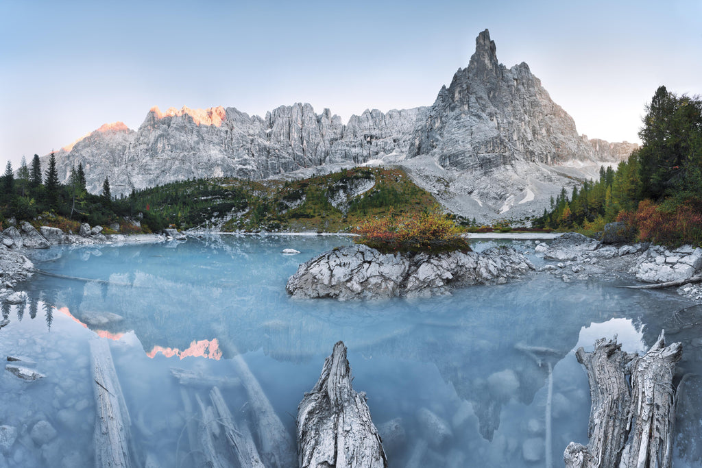 Wandbild-Weiße Berge hinter blauer Wasserlandschaft