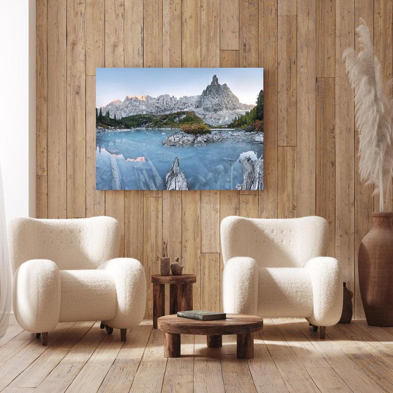 Wandbild - Weiße Berge hinter blauer Wasserlandschaft an Holzwand hinter sanften Sesseln mit Plüschbezug