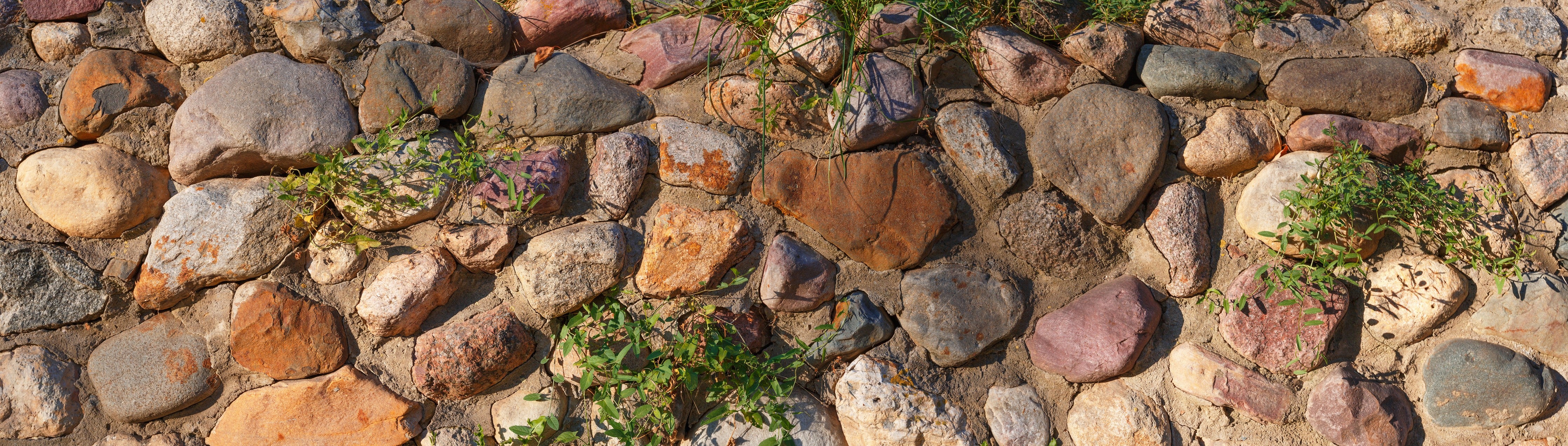 Wandverkleidung Schlafzimmer-Natursteinmauer mit Pflanzen und warmen Tönen