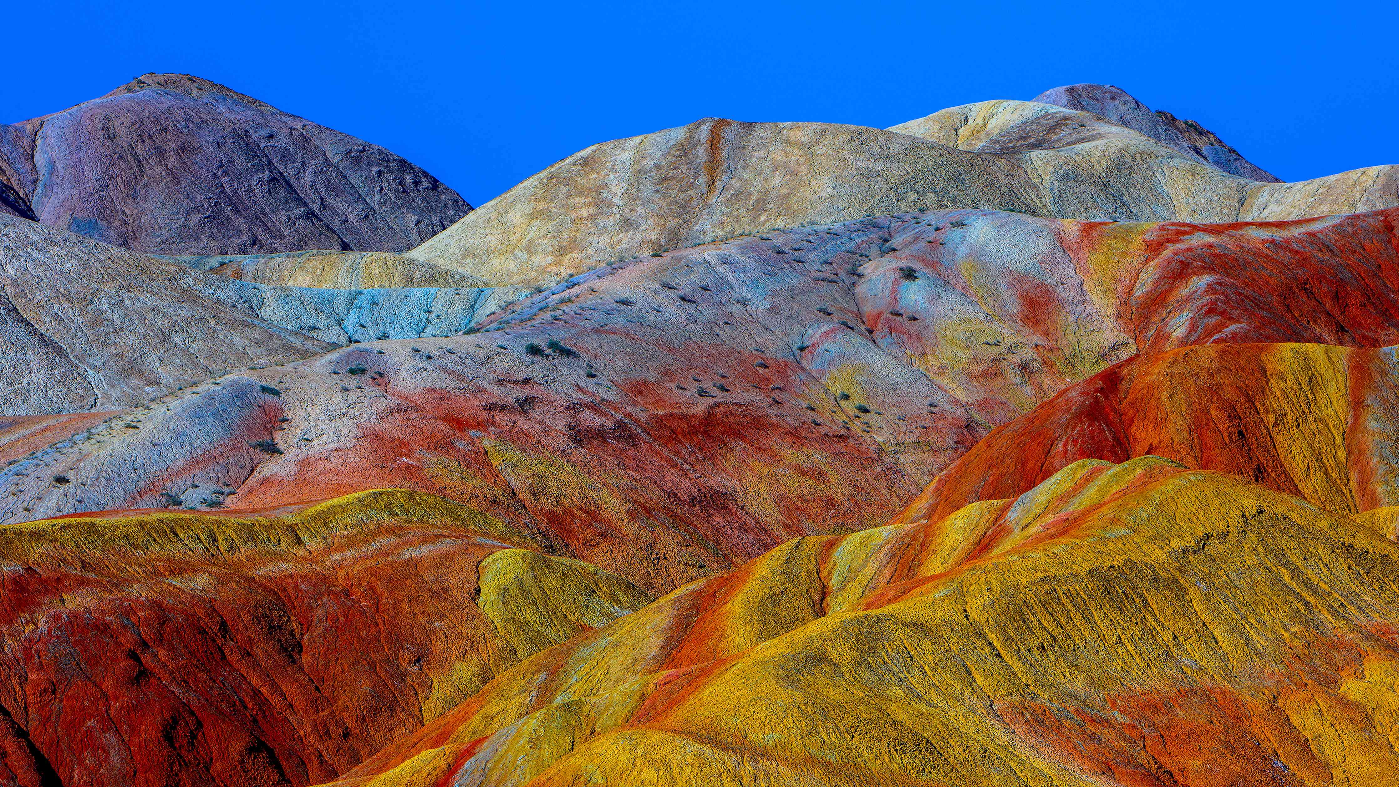 Wandverkleidung Wohnzimmer-Bunte Berglandschaft unter klarem Himmel