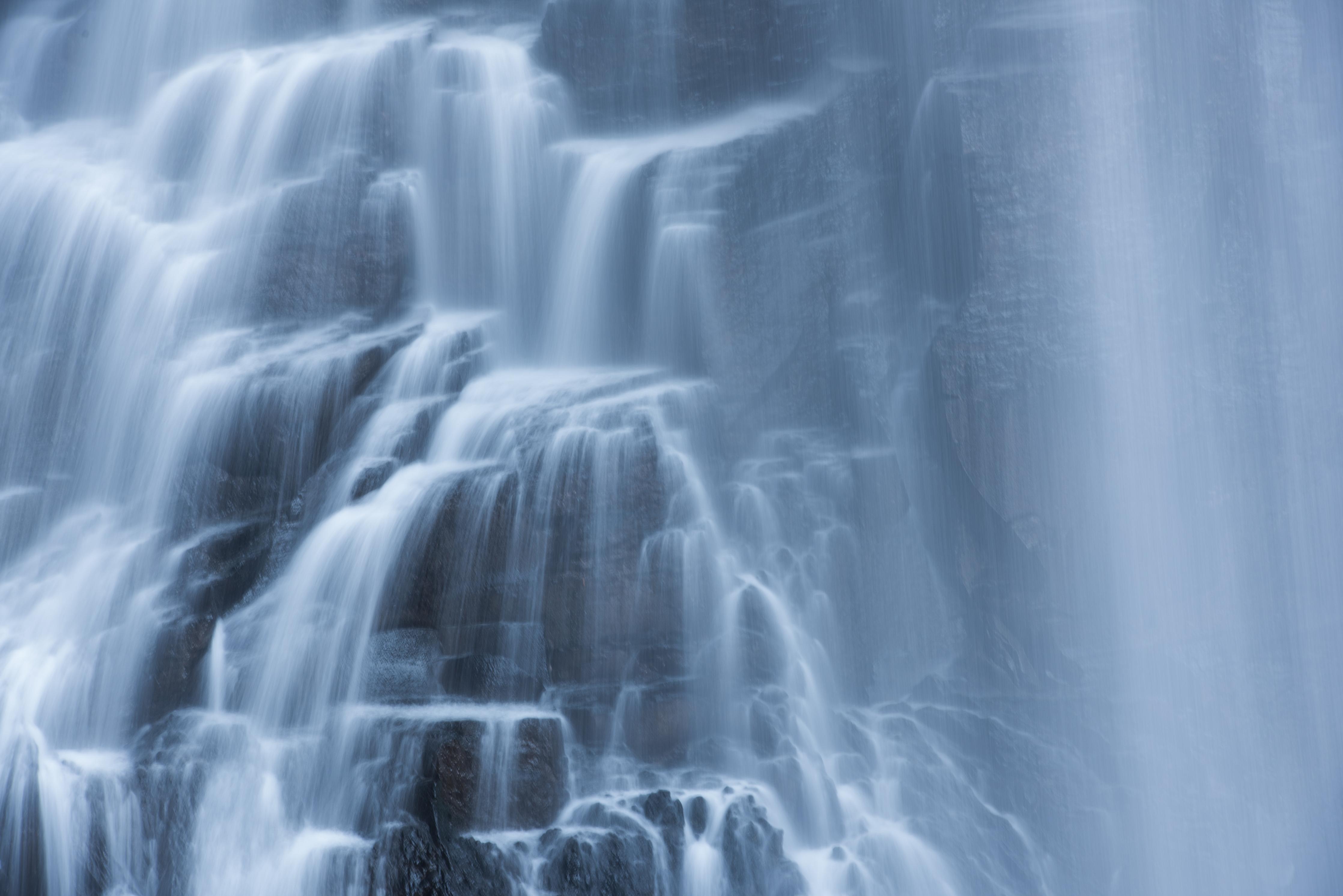 Wandverkleidung Wohnzimmer-Majestätischer Wasserfall in sanftem Wasserlicht