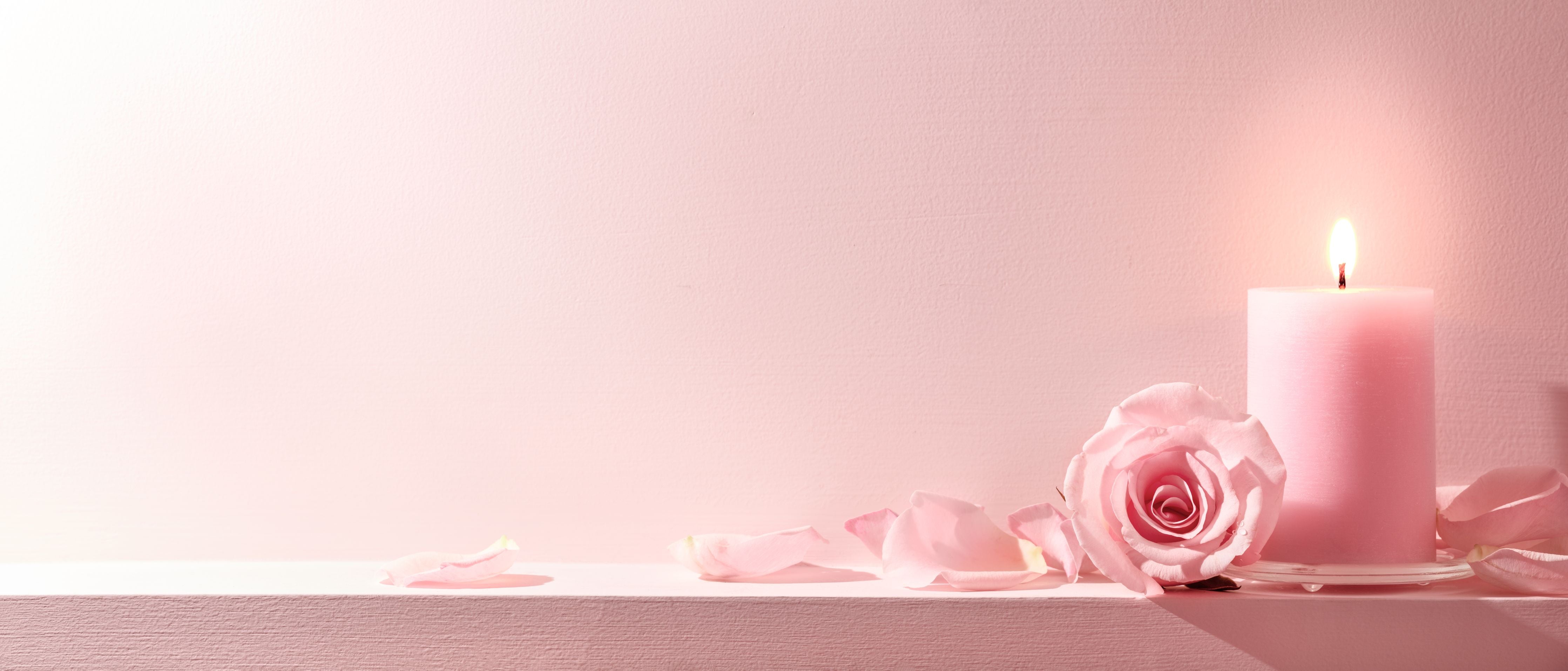 Wandverkleidung Wohnzimmer-Rosa Rosen und Kerze auf einem rosa Hintergrund