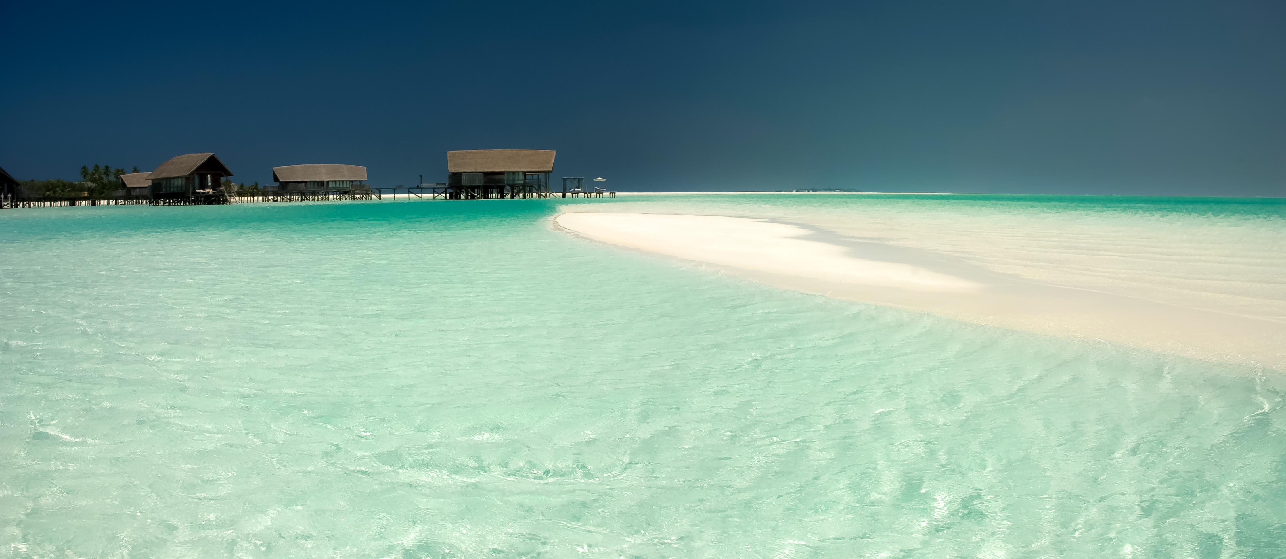 Wandverkleidung Wohnzimmer-Traumhafte Strandkulisse mit kristallklarem Wasser und Sand