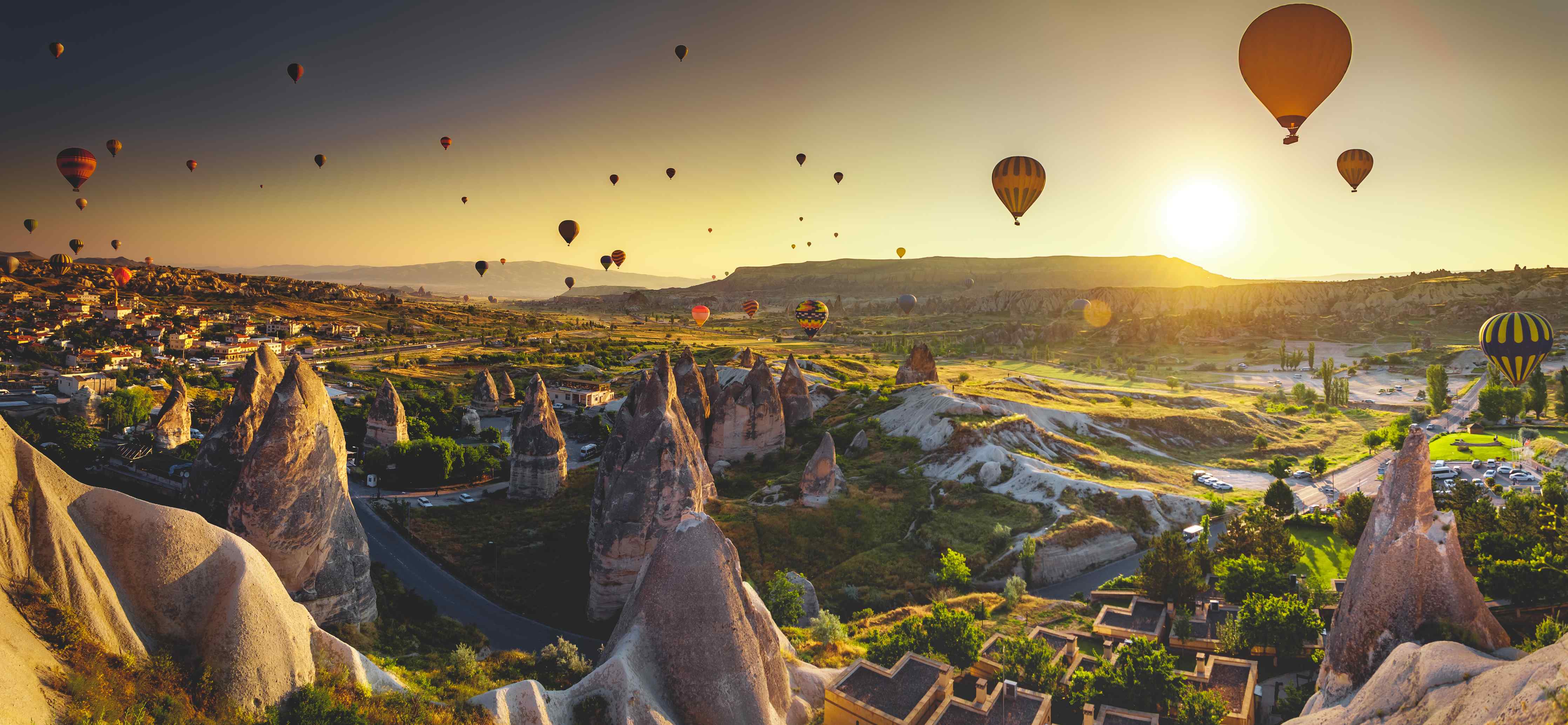 Wandverkleidung außen-Bunte Heißluftballons über einer idyllischen Landschaft bei Sonnenuntergang